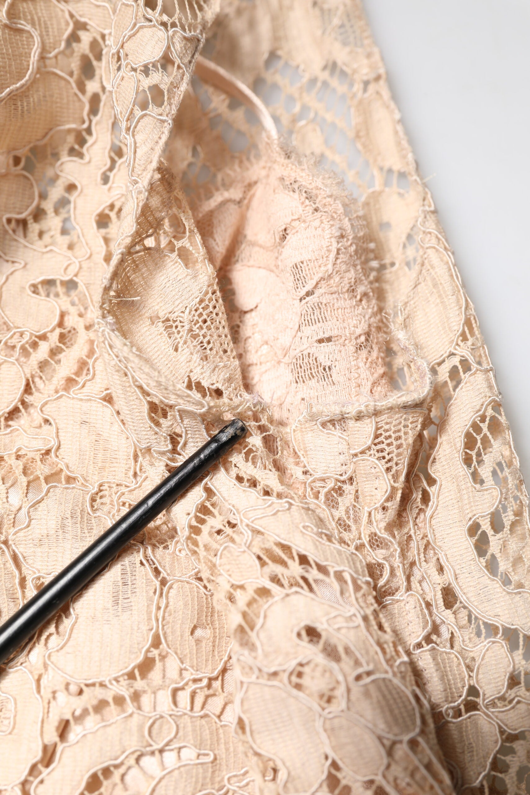 Robe sans manches Dolce & Gabbana en dentelle beige avec motif floral, coupe cintrée élégante et sophistiquée.