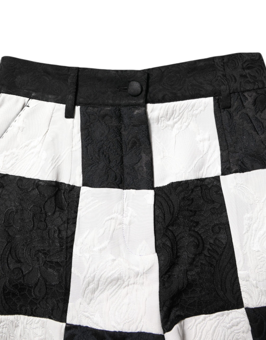 Shorts Dolce & Gabbana en brocart noir et blanc à motif floral, avec coupe courte et détails élégants, style chic et tendance.