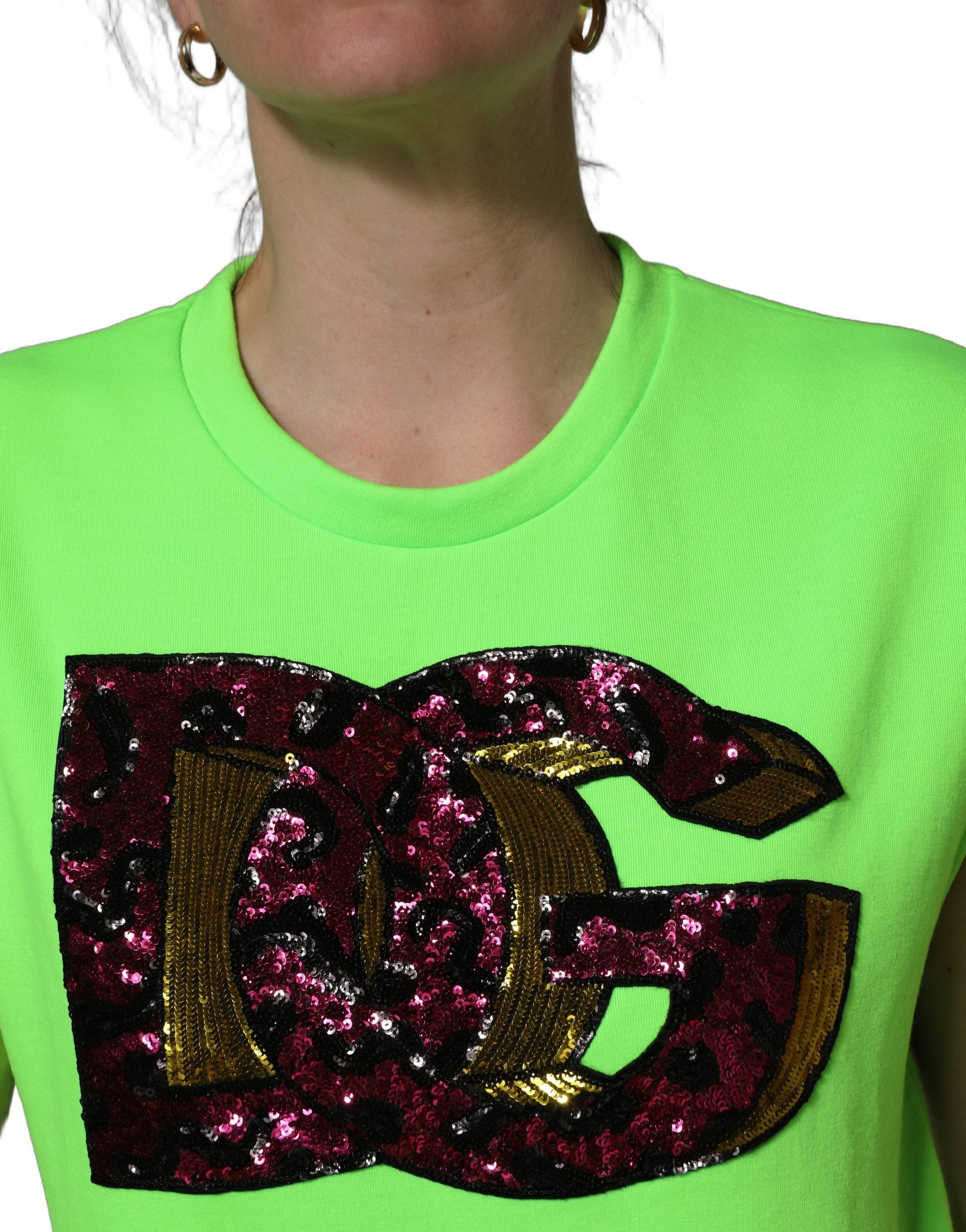 Top sans manches en jersey à sequins vert néon de Dolce & Gabbana, vue en gros plan sur le tissu brillant.