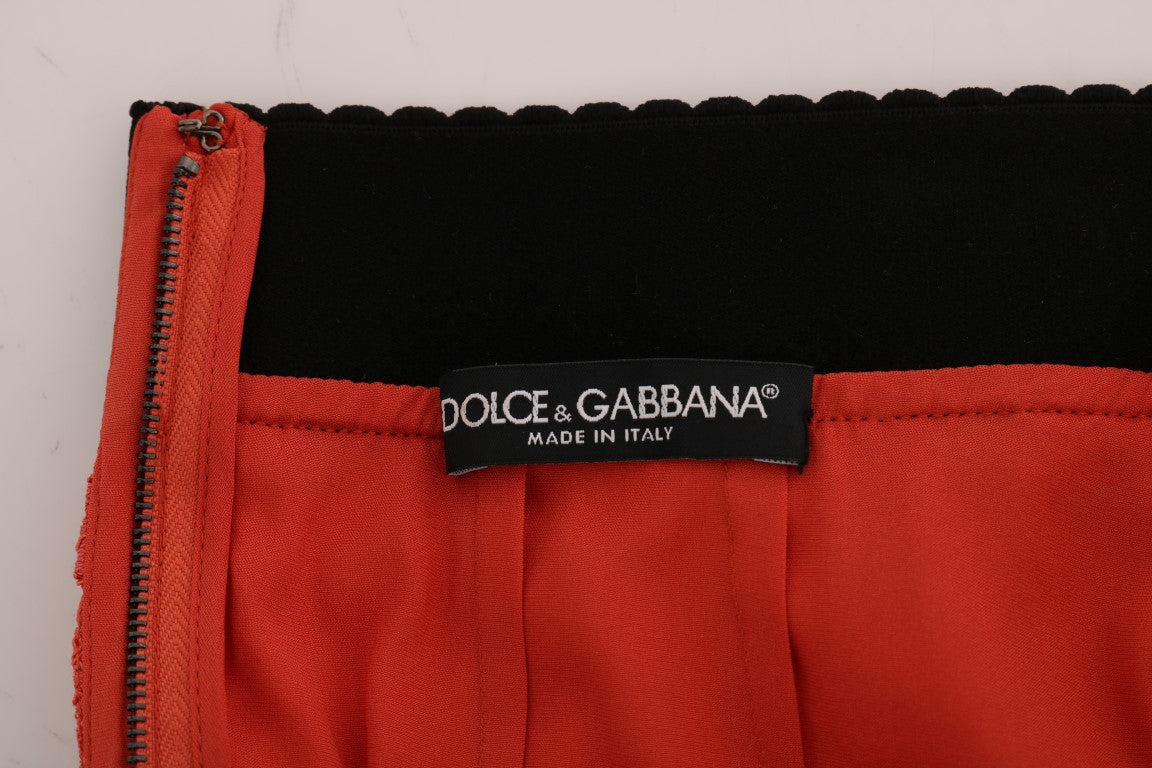 Jupe crayon en dentelle macramé orange de Dolce & Gabbana, détails sophistiqués et texture élégante visible dans l'image.