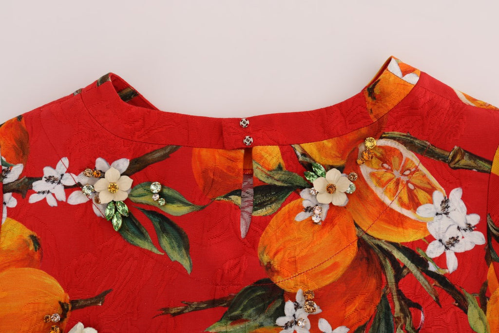 Blouse Dolce & Gabbana à imprimé orange avec cristaux scintillants, tissu fluide et détails élégants.