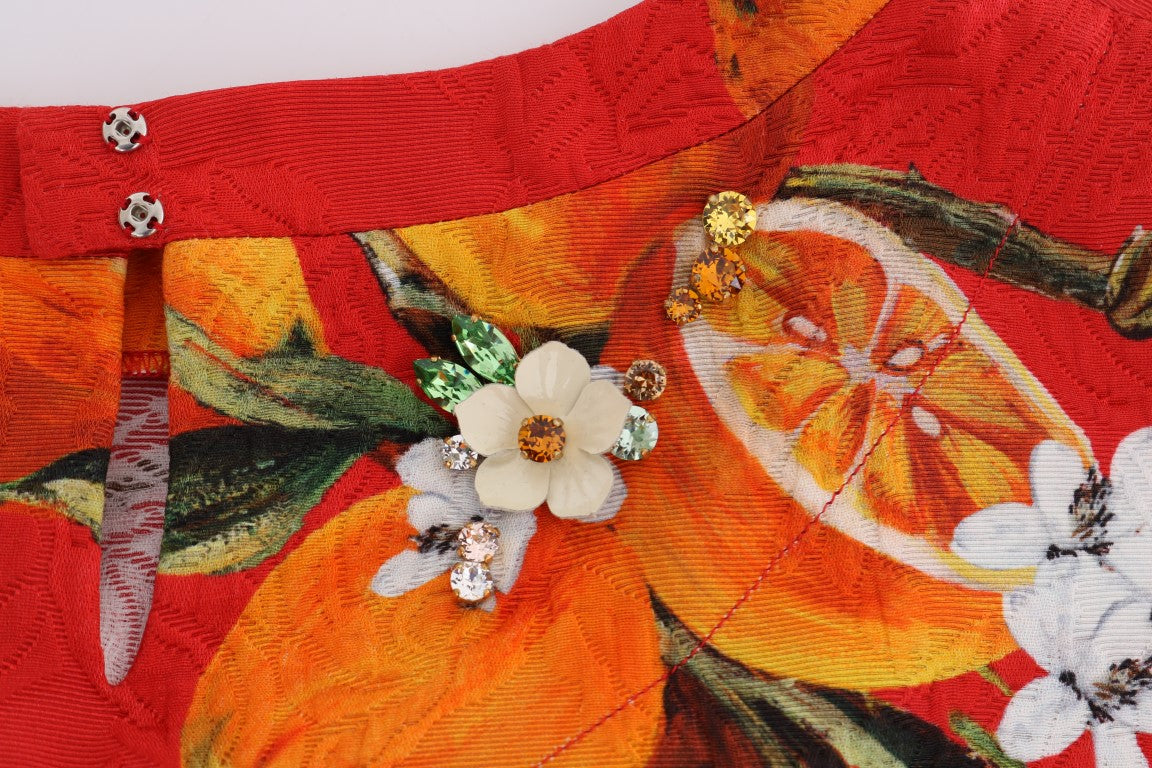 Blouse Dolce & Gabbana à imprimé orange avec cristaux, élégante et raffinée, portée avec détails visibles.