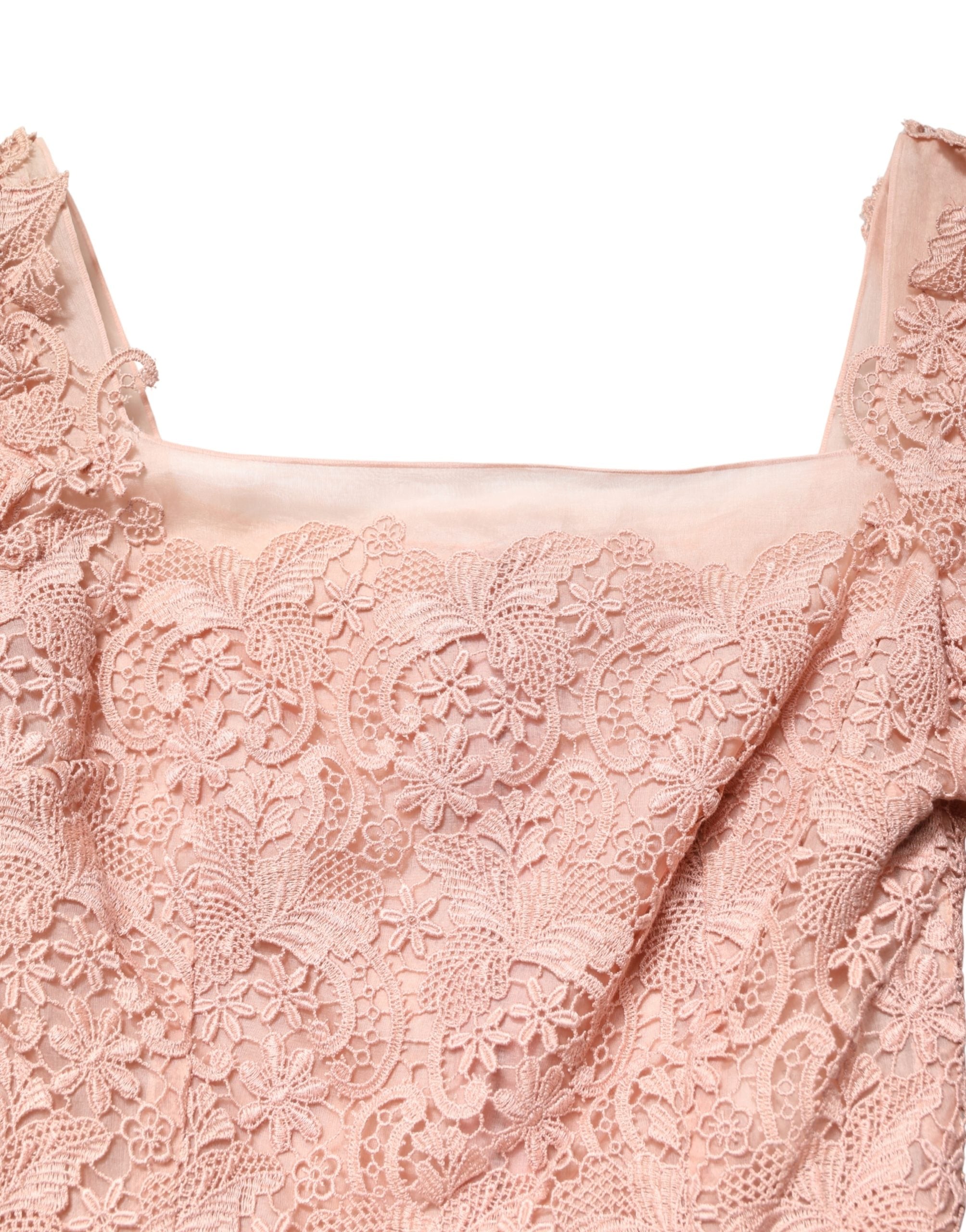 Robe de soirée Dolce & Gabbana en dentelle rose à manches longues, élégante et sophistiquée, portée par un mannequin.