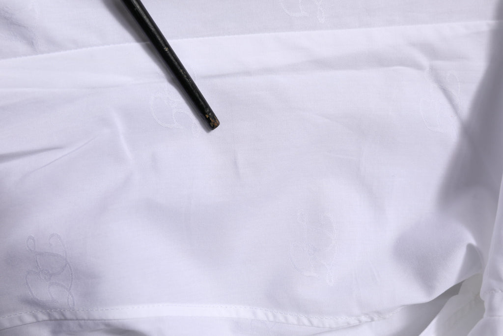 Chemise formelle Dolce & Gabbana blanche en coton avec manches longues et détails dorés, vue de face.