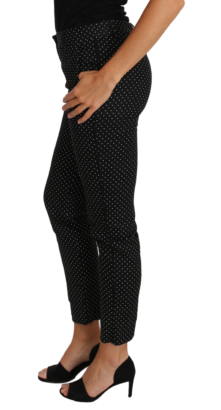 Robe noire Dolce & Gabbana avec pois, coupe courte et pantalons droits, élégante et tendance, portée dans une image mode.