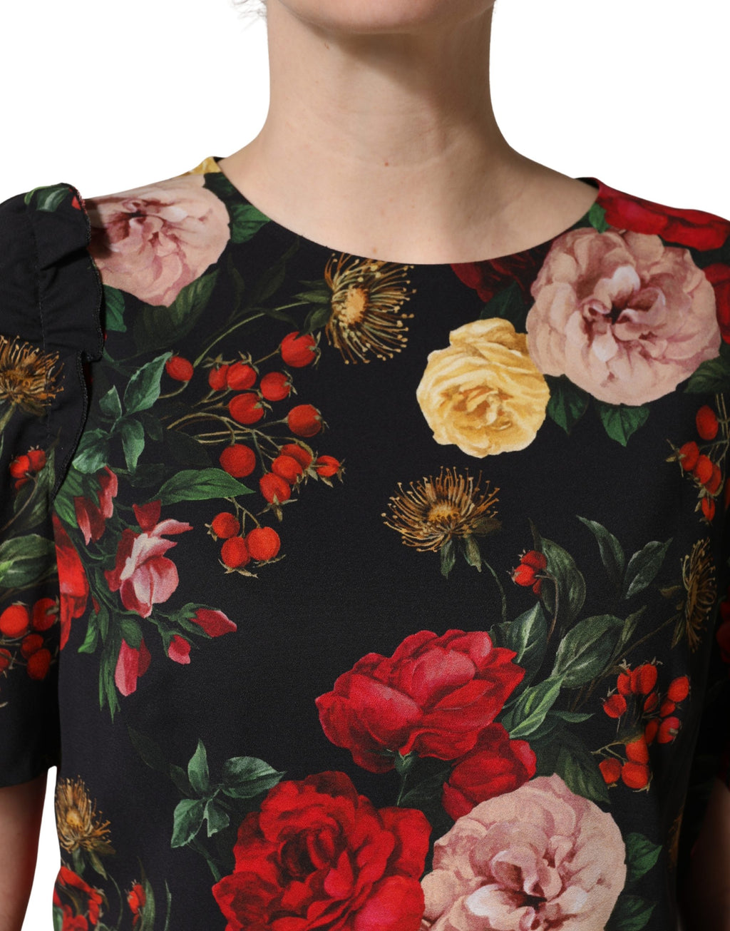 Blouse noire Dolce & Gabbana en crêpe avec détails en volants et motif floral, manches longues et style élégant.
