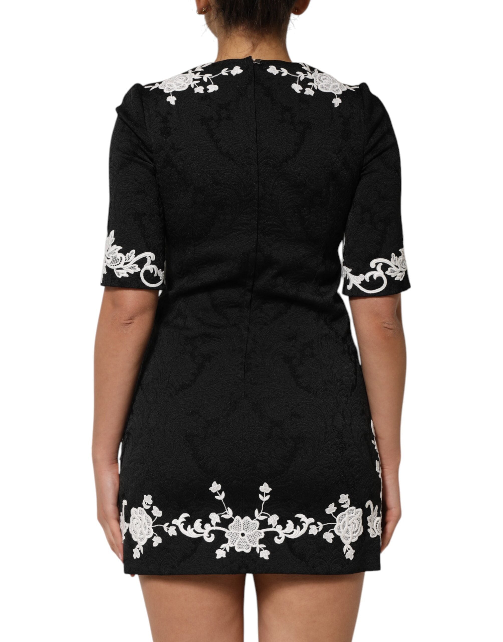 Robe Dolce & Gabbana noire avec dentelle, manches courtes et coupe en forme d'éventail, élégante et raffinée.
