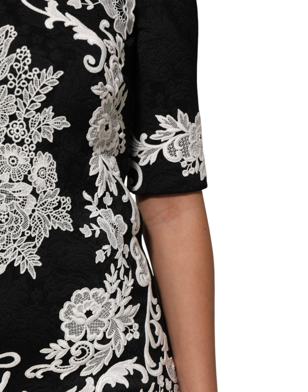 Robe Dolce & Gabbana noire en dentelle avec manches courtes et coupe évasée, détail de finition en dentelle noire.