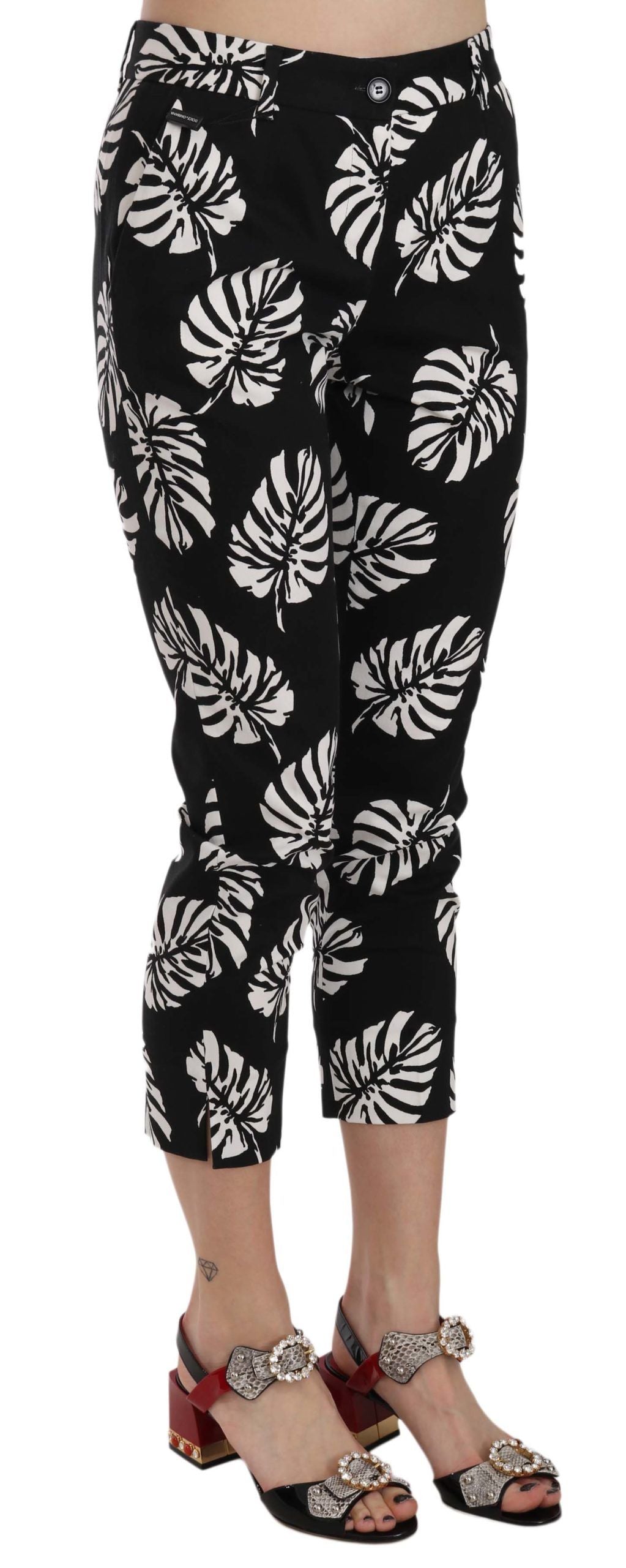 Pantalons skinny noirs Dolce & Gabbana à motif palmier imprimé, ajustés, avec ceinture élégante, sur fond neutre.