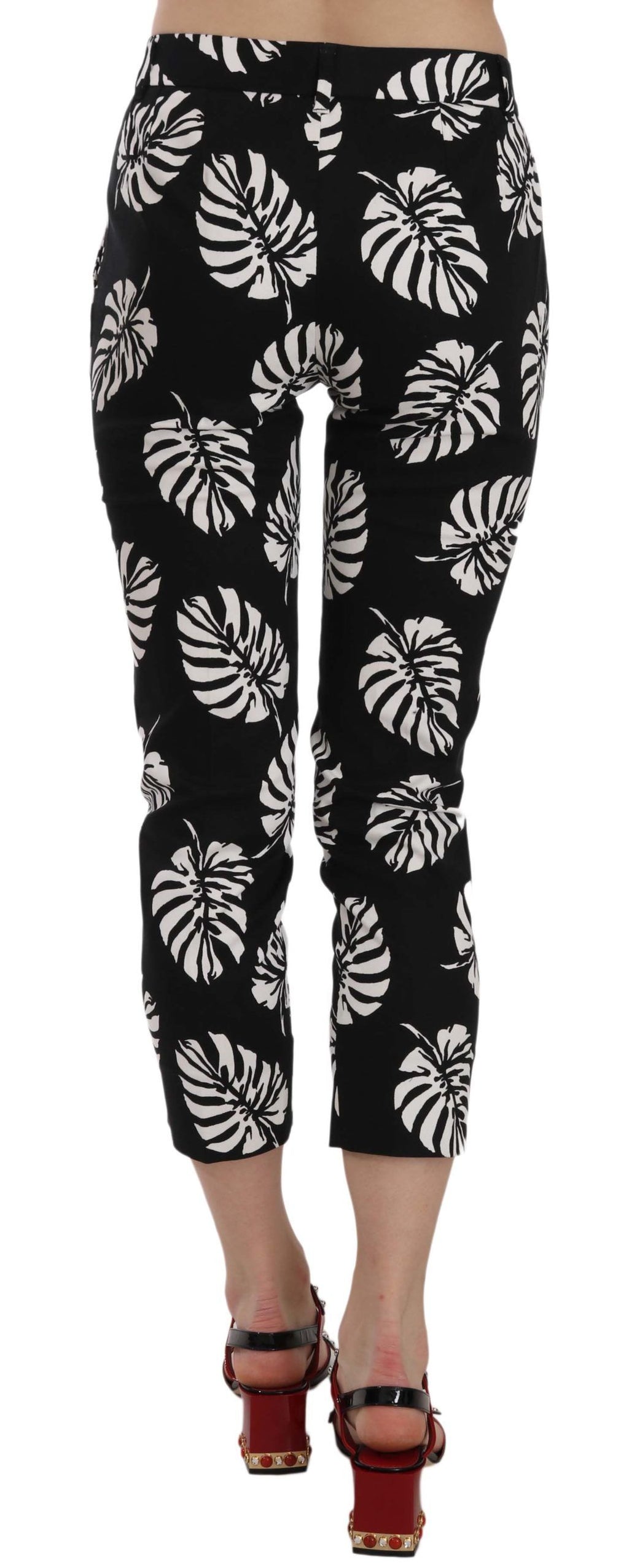 Pantalons skinny noirs Dolce & Gabbana avec imprimé feuilles de palmier noirs et verts, taille ajustée et style élégant.