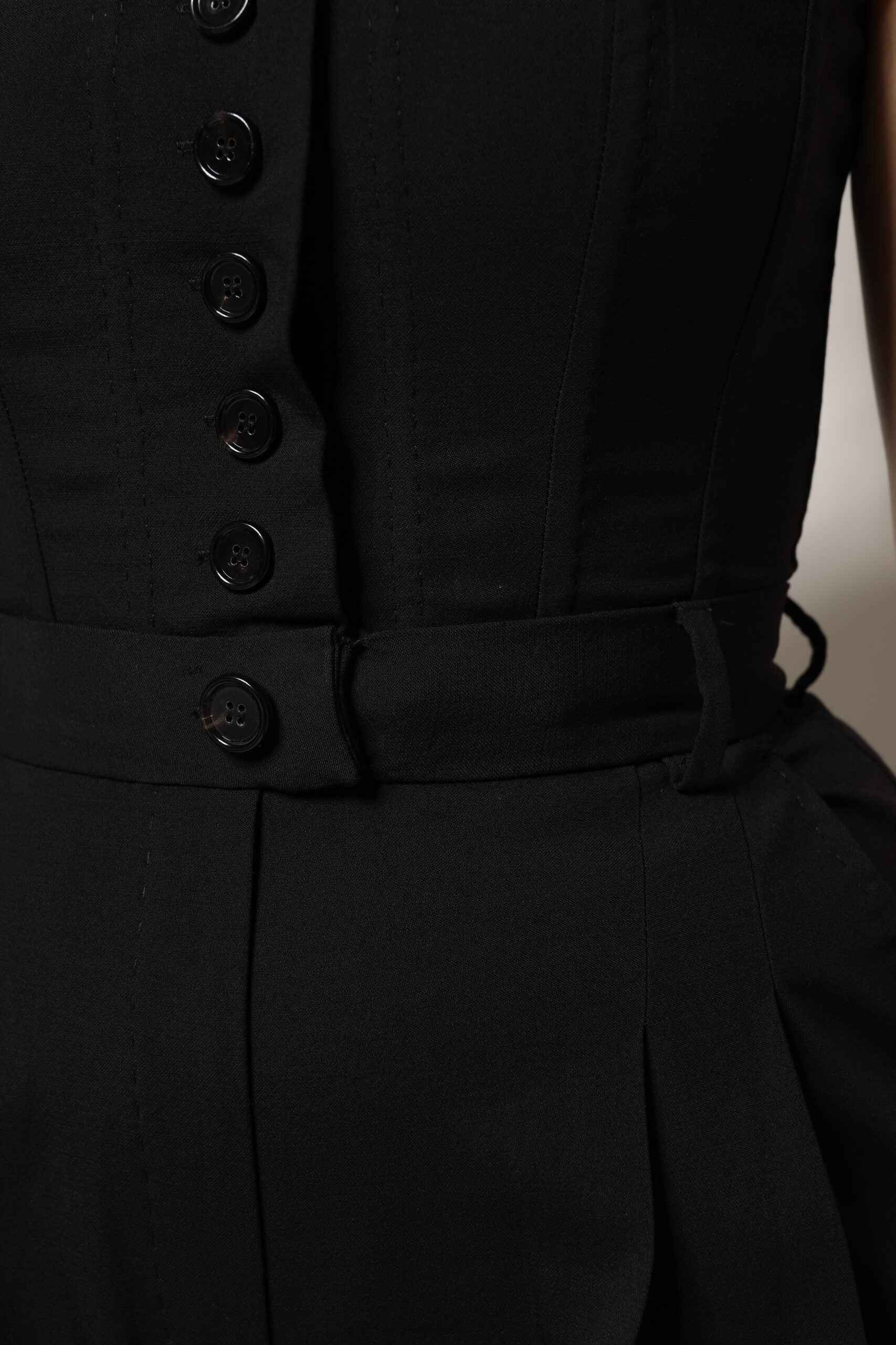 Combinaison courte en laine noire Dolce & Gabbana sans bretelles, élégante et ajustée, portée sur un fond neutre.