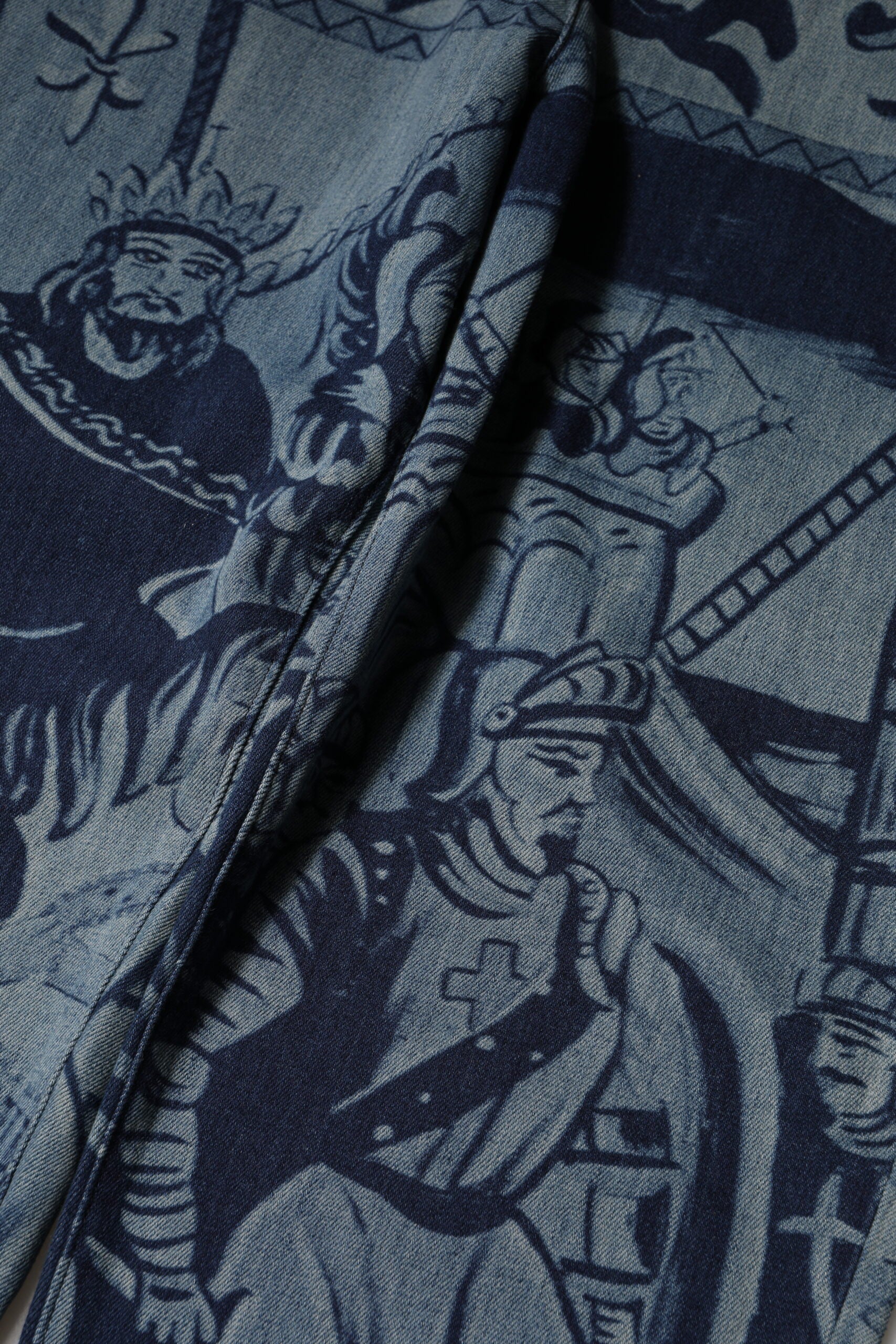 Jeans en denim bleu Dolce & Gabbana à imprimé graphique, coupe tapered, visibles sur le produit.