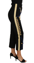 Pantalon habillé noir Dolce & Gabbana avec embellissements militaires dorés, style élégant et sophistiqué.