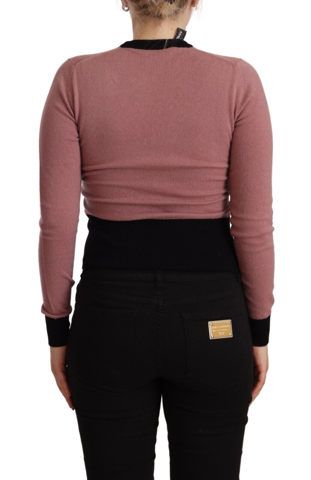Pull en cachemire rose Dolce & Gabbana, col rond, pull sartorial élégant, visible détails de texture et finition raffinée.