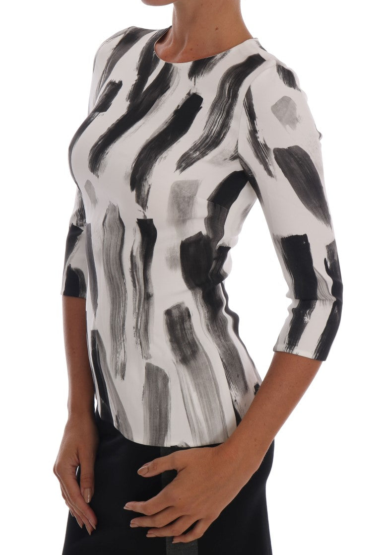 Chemisier Dolce & Gabbana à rayures blanches et noires, imprimé élégant, en tissu léger avec col et manches longues.