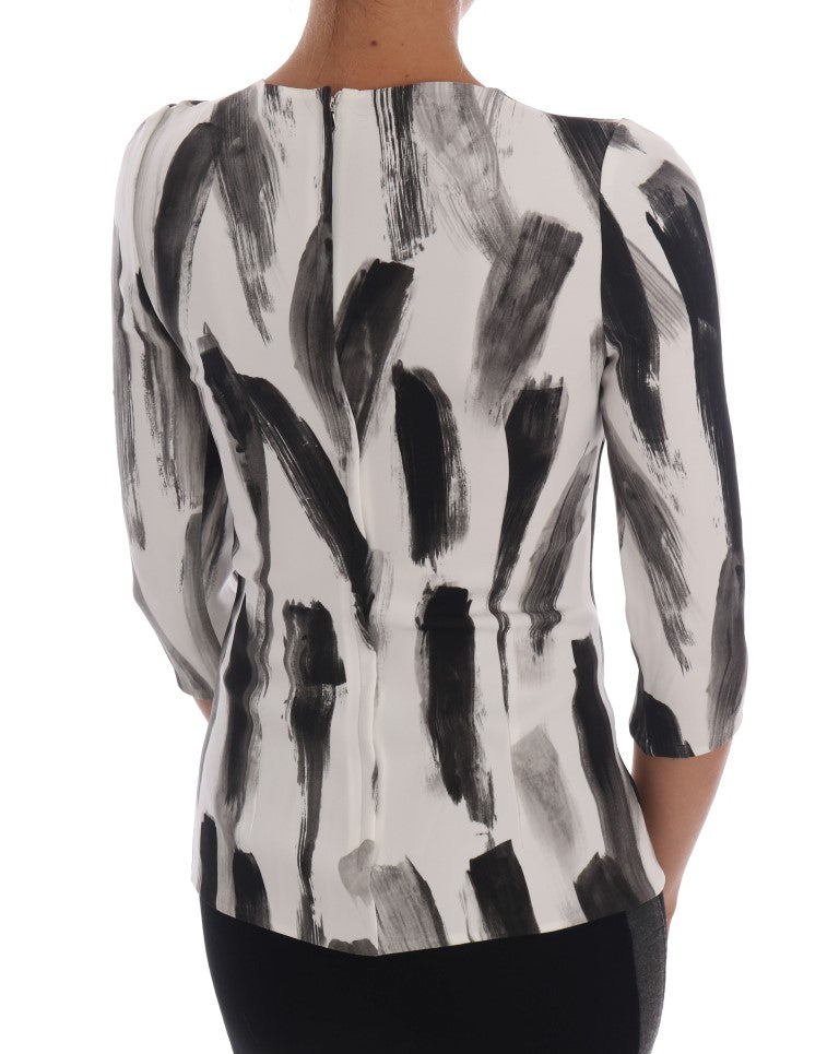Chemisier Dolce & Gabbana à rayures blanches et noires avec imprimé, manches longues et coupe élégante.