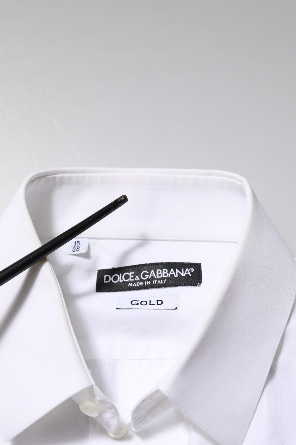 Chemise blanche en coton Dolce & Gabbana à manches longues, élégante et formelle, avec détails dorés visibles sur l'image.