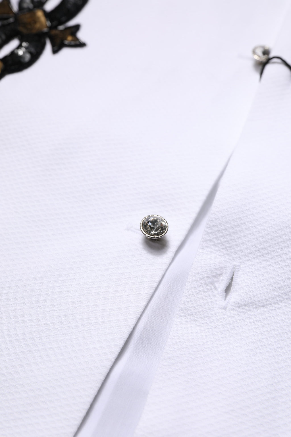 Chemise formelle blanche pour homme de Dolce & Gabbana avec embellissements dorés et détails élégants.