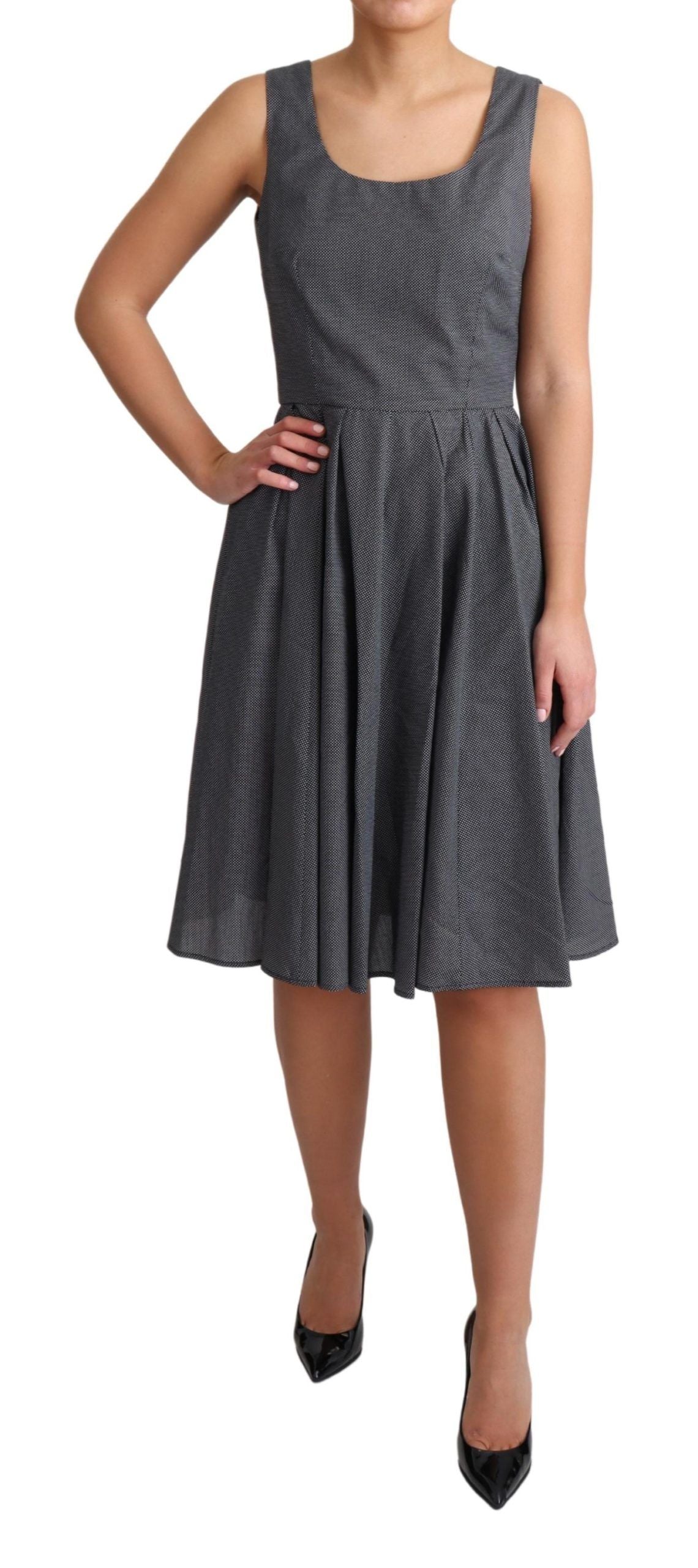 Robe noire à pois en coton Dolce & Gabbana, coupe évasée et élégante, avec motif à pois noirs sur fond blanc.