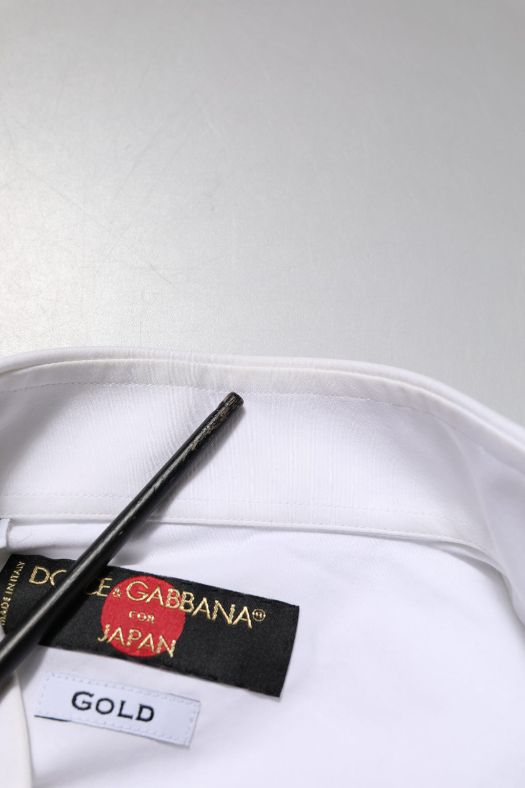 Chemise formelle blanche Dolce & Gabbana en coton avec détails dorés, veste ou robe bib élégante et sophistiquée.
