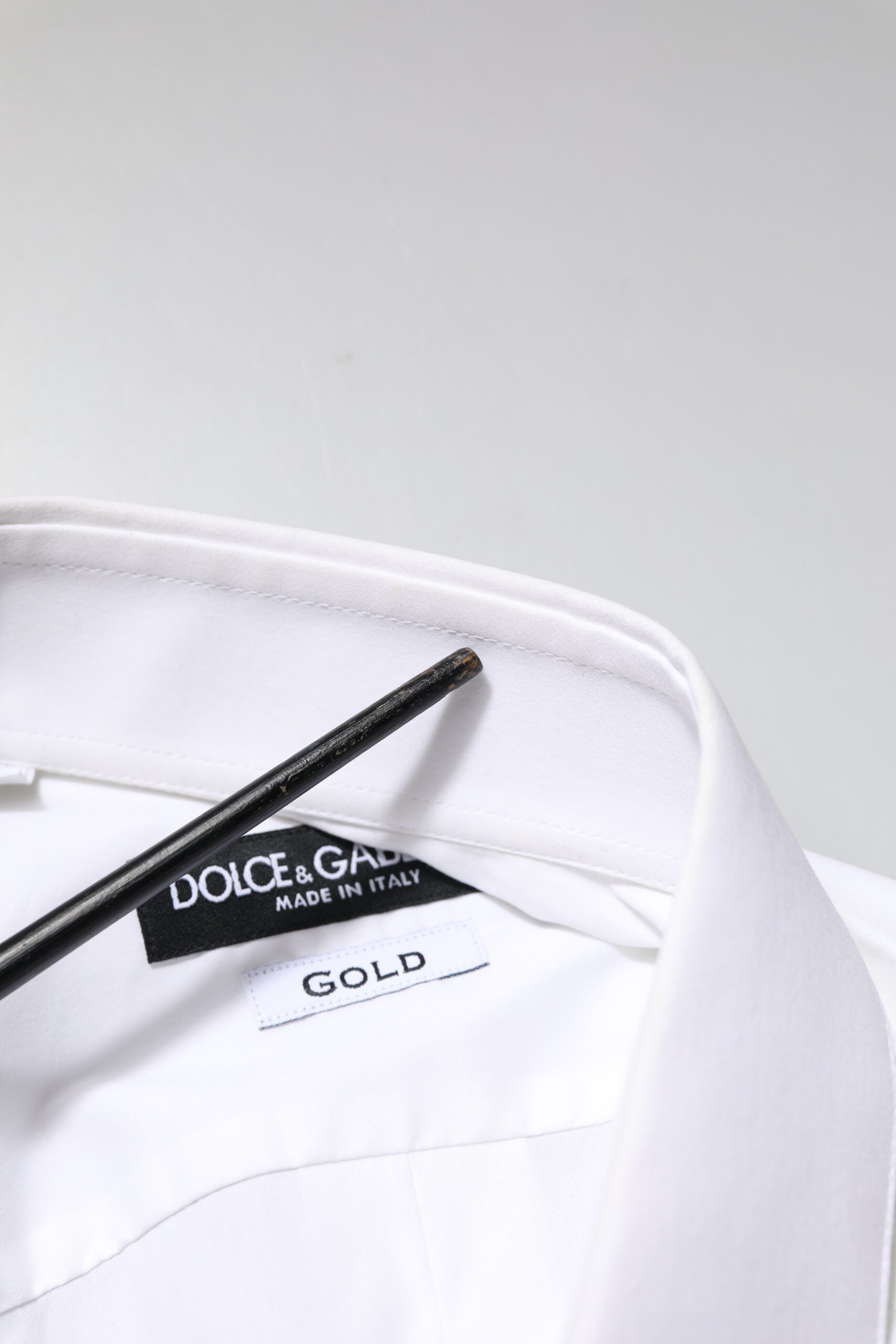 Chemise formelle blanche à manches longues Dolce & Gabbana avec accents dorés, élégante et sophistiquée.