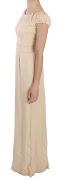 Robe longue beige en soie Dolce & Gabbana à colonne avec manches cap, élégante et fluide, portée pour une occasion spéciale.