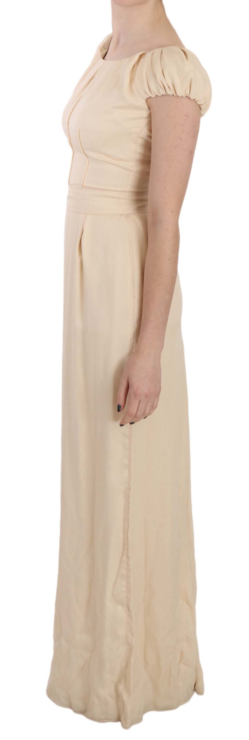 Robe longue beige en soie Dolce & Gabbana à colonne avec manches cap, élégante et fluide, portée pour une occasion spéciale.