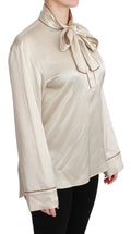 Haut en soie satin beige Dolce & Gabbana avec manches longues, style blouse élégante pour femme.