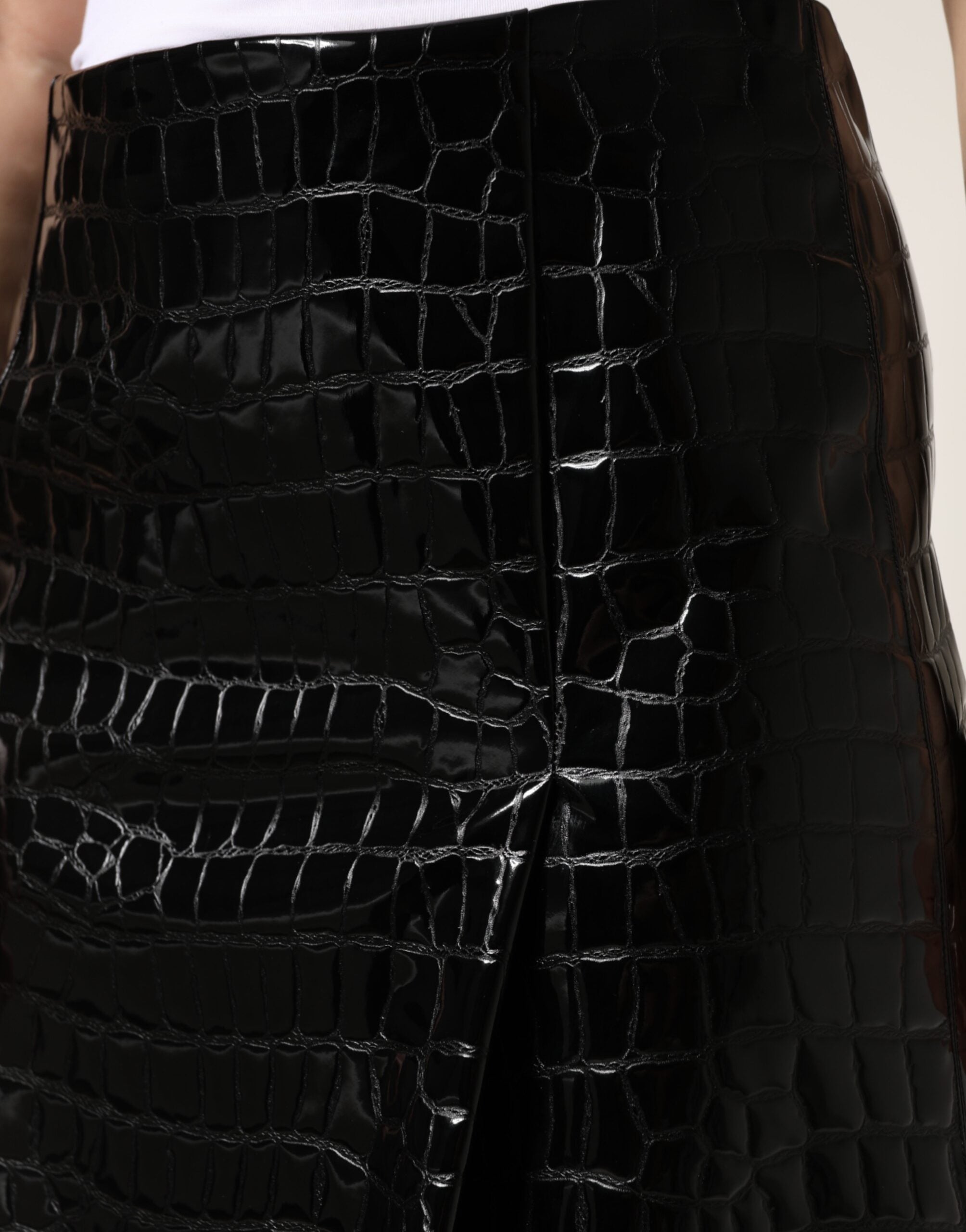 Jupe midi noire Dolce & Gabbana en faux-crocodile, taille moyenne, en cuir synthétique, vue de face sur fond blanc.