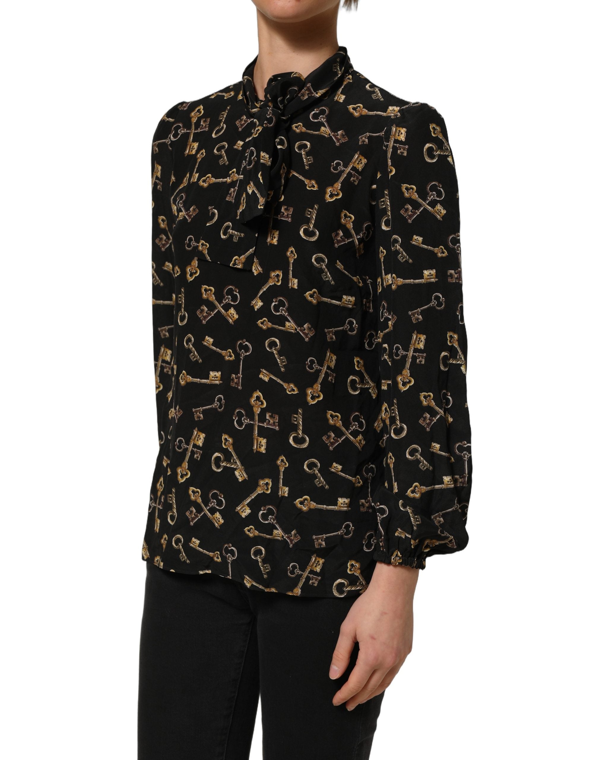 Blouse en soie noire Dolce & Gabbana avec motif de clés, col en nœud et design élégant, vue de face.