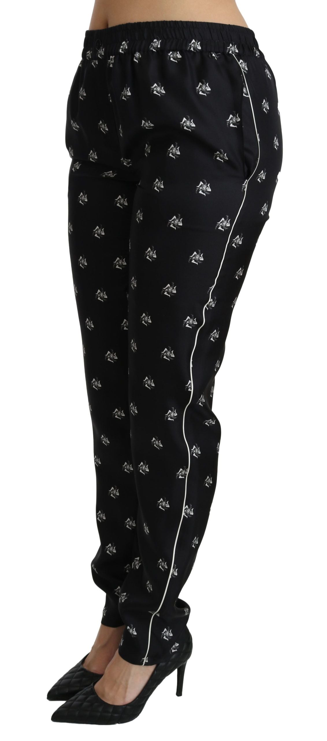 Pantalons en soie noirs Dolce & Gabbana, coupe skinny taille moyenne avec motif imprimé, visibles sur l’image.