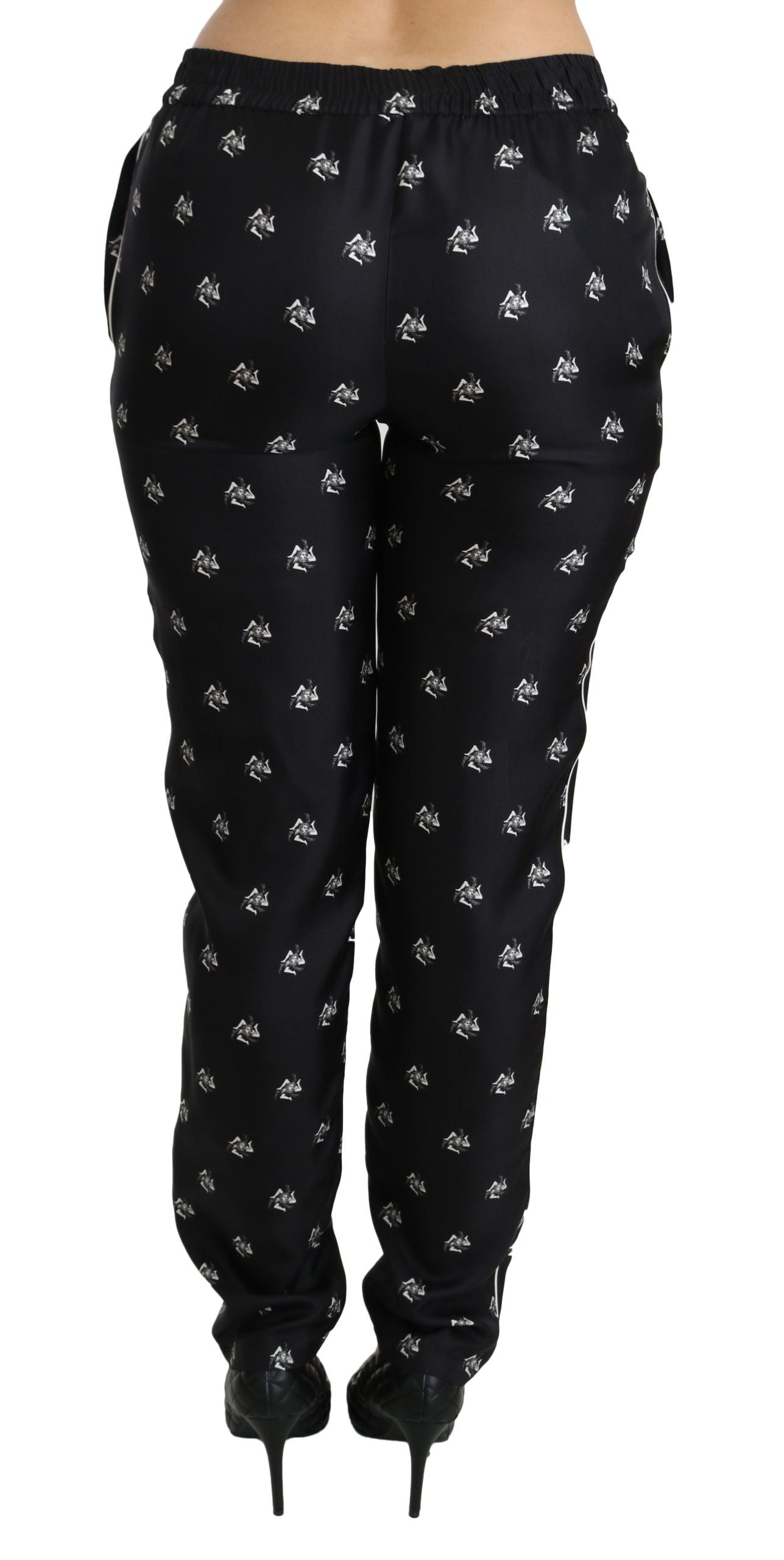 Pantalon skinny en soie noire à imprimé, taille mi-haute, de la marque Dolce & Gabbana, visible en détail sur l'image.