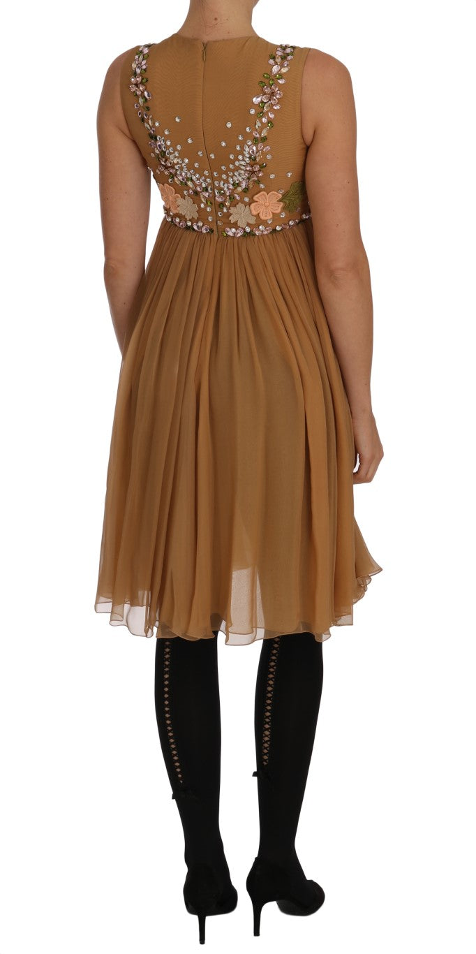 Robe longue en soie cristal dorée Dolce & Gabbana avec coupe évasée et détails élégants, portée pour une occasion sophistiquée.