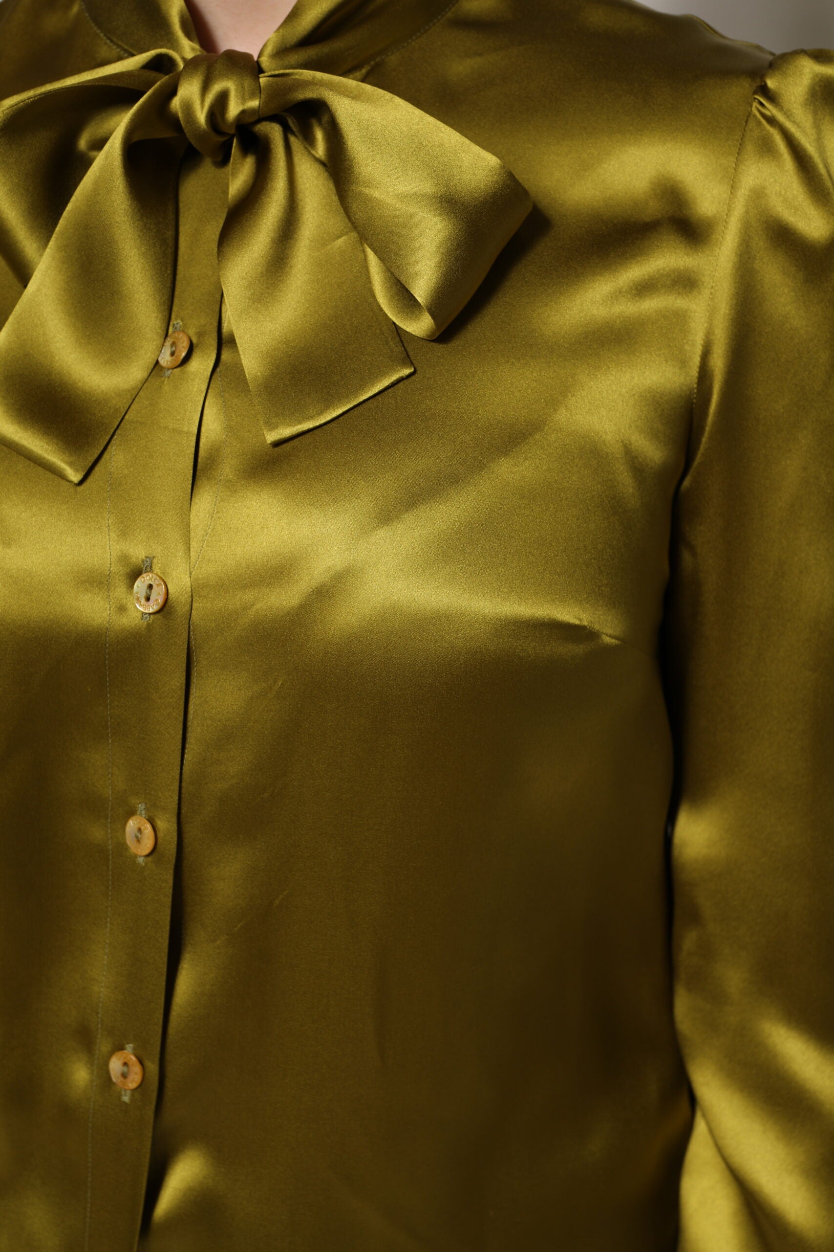 Chemisier à manches longues Dolce & Gabbana avec col ascot vert, détail élégant et tissu fluide visible sur l'image.