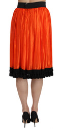 Jupe orange à taille haute et longueur genou par Dolce & Gabbana, en tissu fluide et élégant.