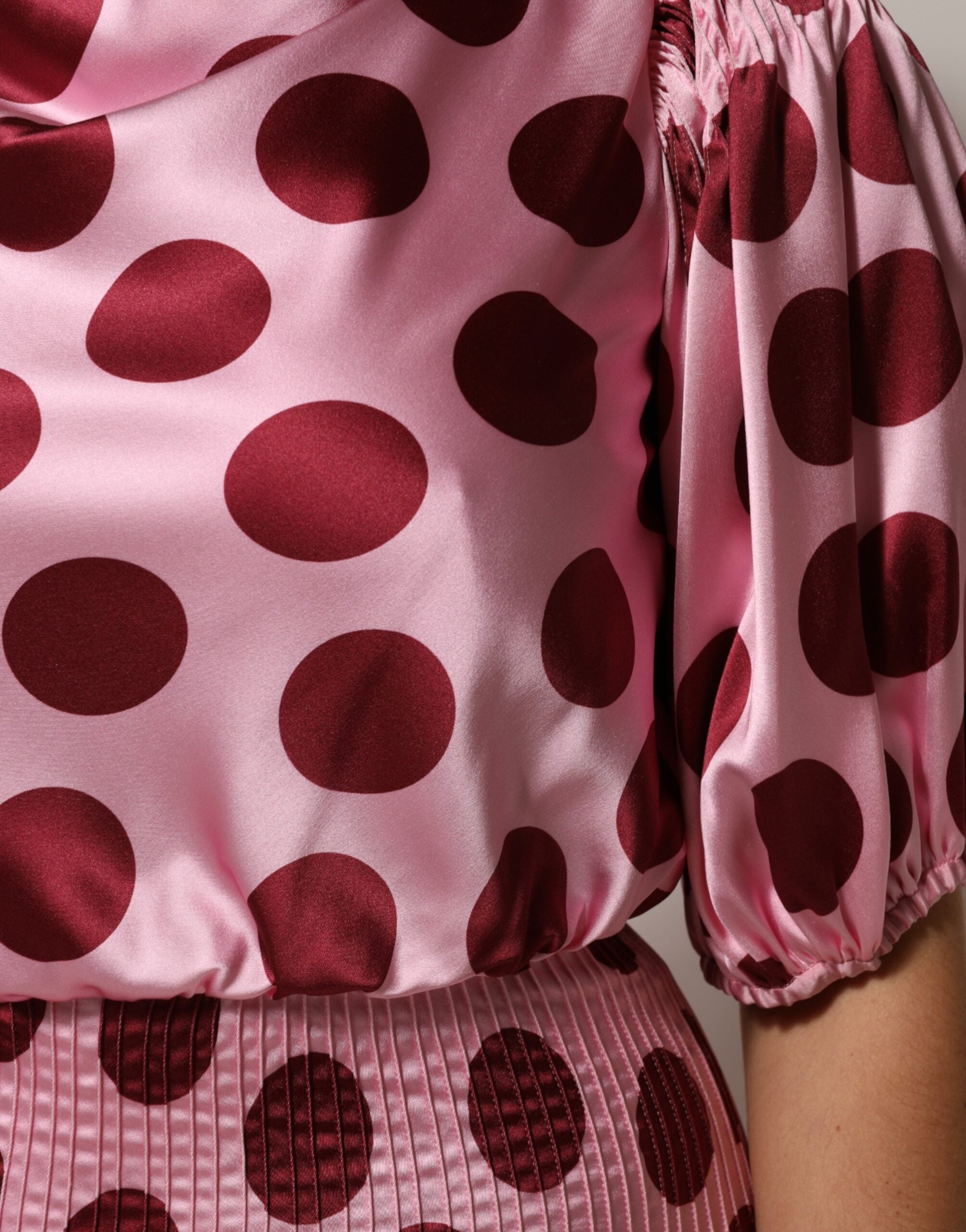 Robe maxi en soie et satin à pois roses et rouges de Dolce & Gabbana, élégante et fluide, portée avec finesse.
