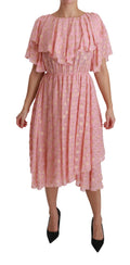 Robe midi en soie rose à pois blancs, plissée et évasée, de la marque Dolce & Gabbana, vue de face.