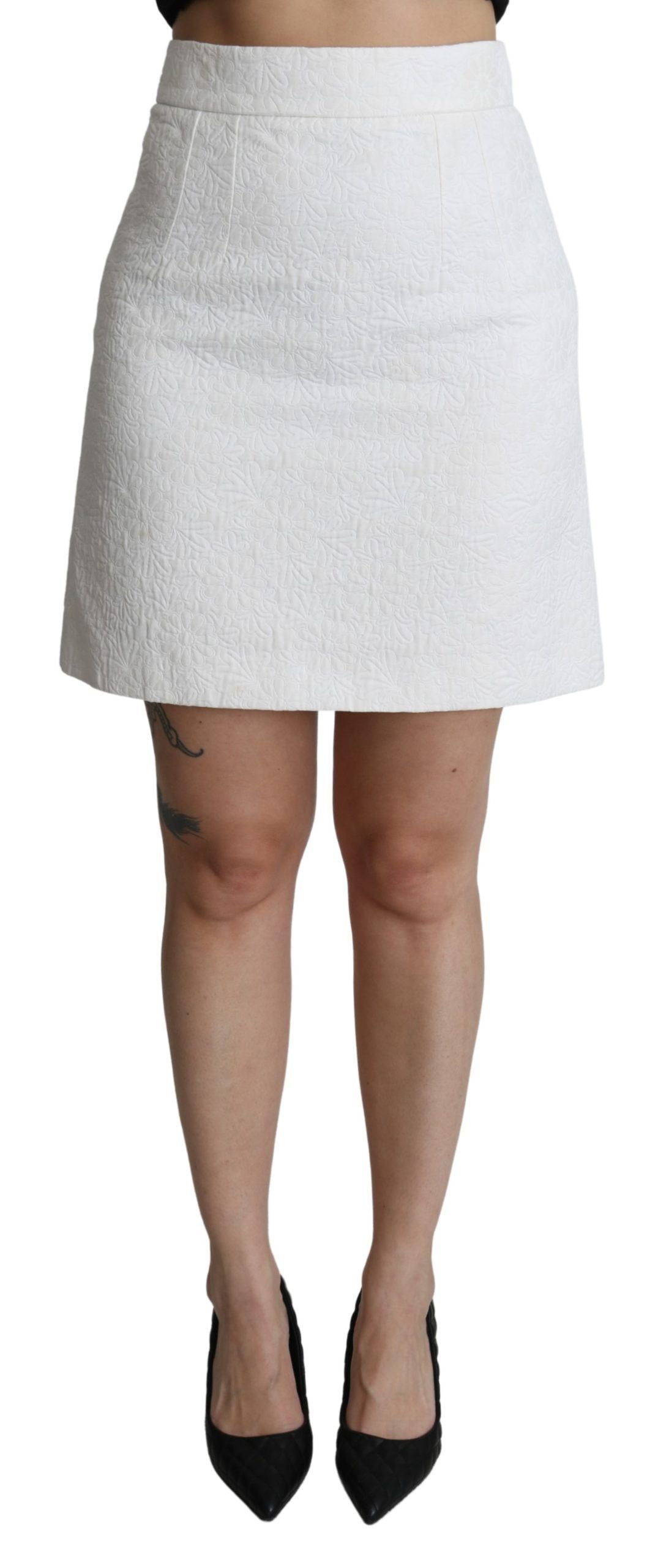 Jupe courte en brocart blanc à taille haute avec motifs floraux, par Dolce & Gabbana, vue de face.