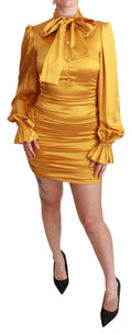 Robe courte Dolce & Gabbana en soie jaune, coupe ajustée et moulante, style bodycon, portée élégante.