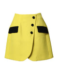 Mini jupe en laine jaune à boutons, taille haute, de la marque Dolce & Gabbana, vue de face.