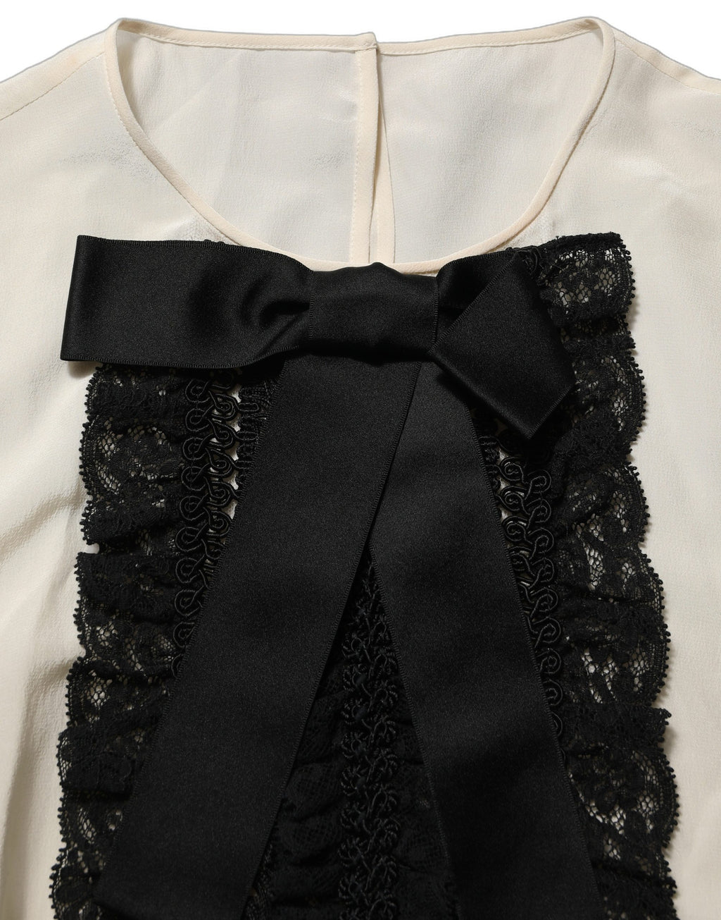 Blouse courte beige Dolce & Gabbana avec bordure en dentelle et nœud, manches courtes élégantes et féminines.