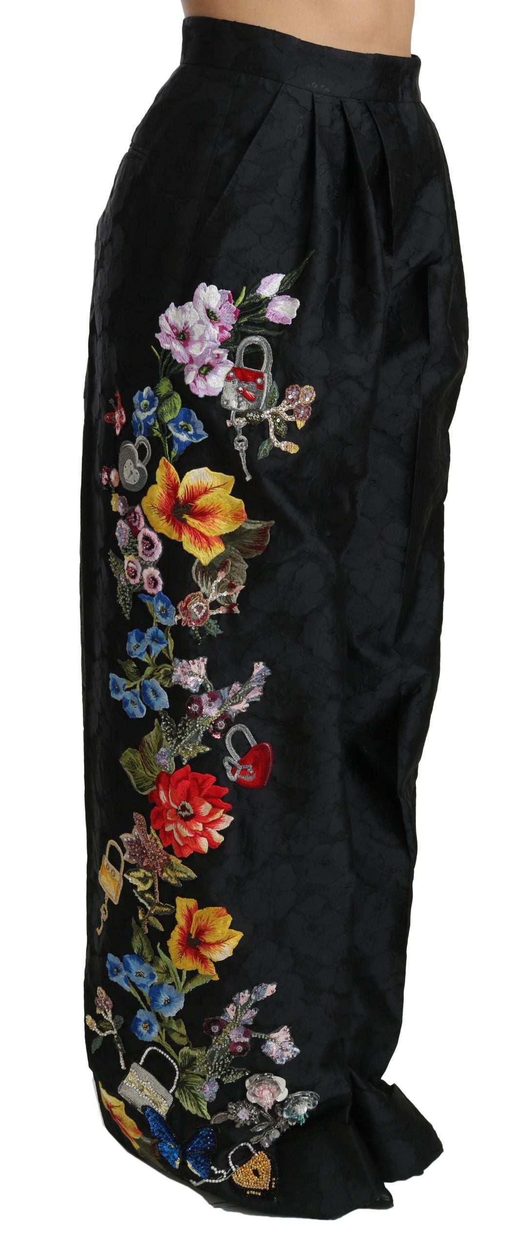 Pantalons noirs en brocart floral, ornés de sequins et de perles, de la marque Dolce & Gabbana, visibles en gros plan.