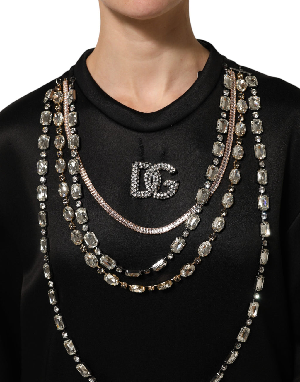 Pull à capuche Dolce & Gabbana noir avec collier en cristal DG visible, style élégant et casual, en tissu doux.