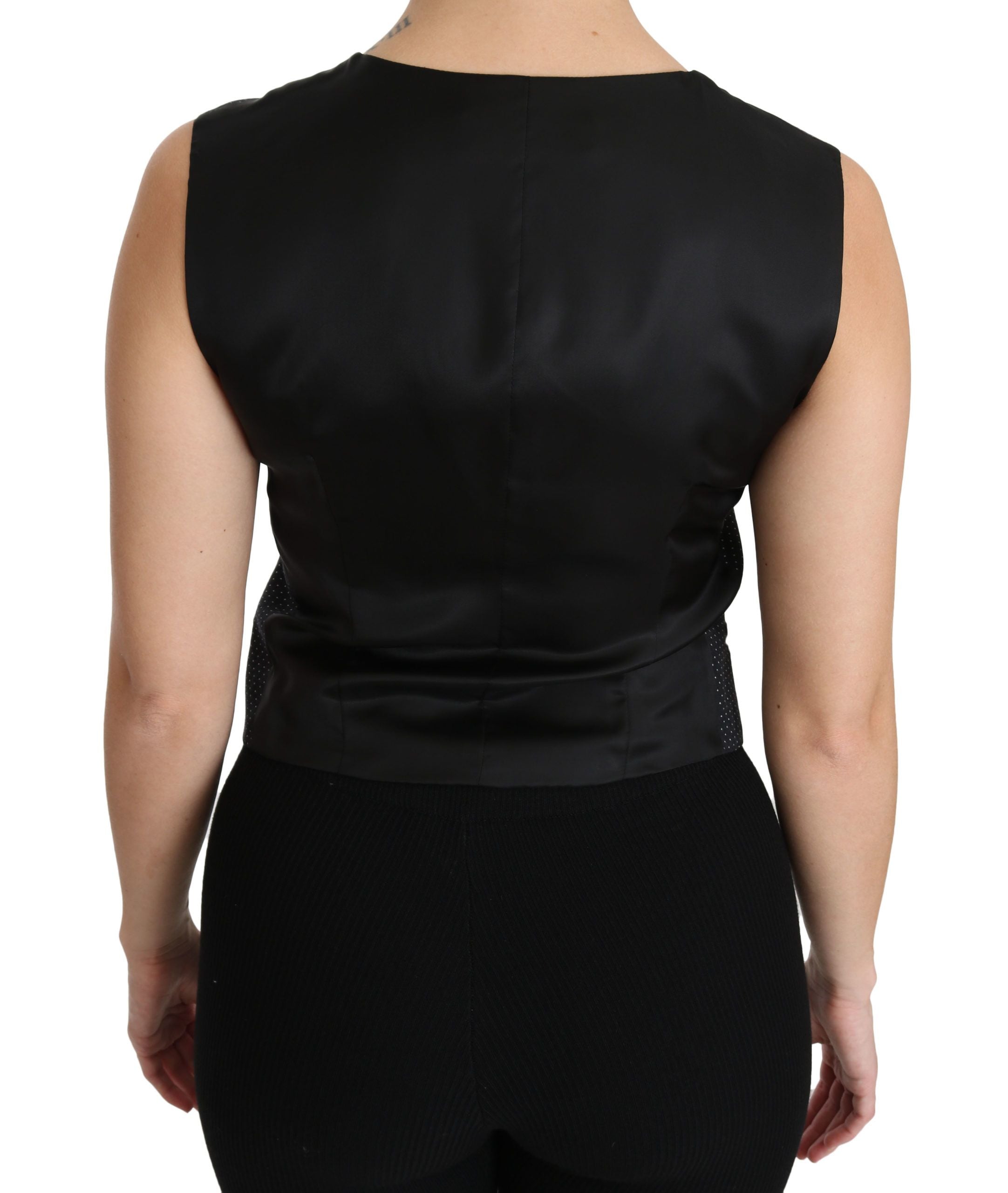 Veste sans manches noire à pois Dolce & Gabbana, avec col en V et détails élégants, portée comme blouse ou haut de mode.