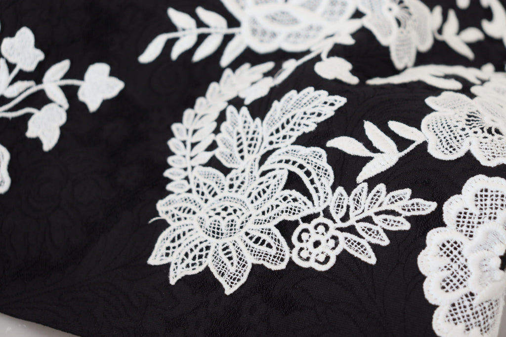 Robe noire Dolce & Gabbana à manches mi-longues avec bordure en dentelle et coupe évasée, élégante et sophistiquée.