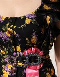 Robe midi en soie noire et violette avec broche en cristaux de Dolce & Gabbana, détails élégants et sophistiqués.