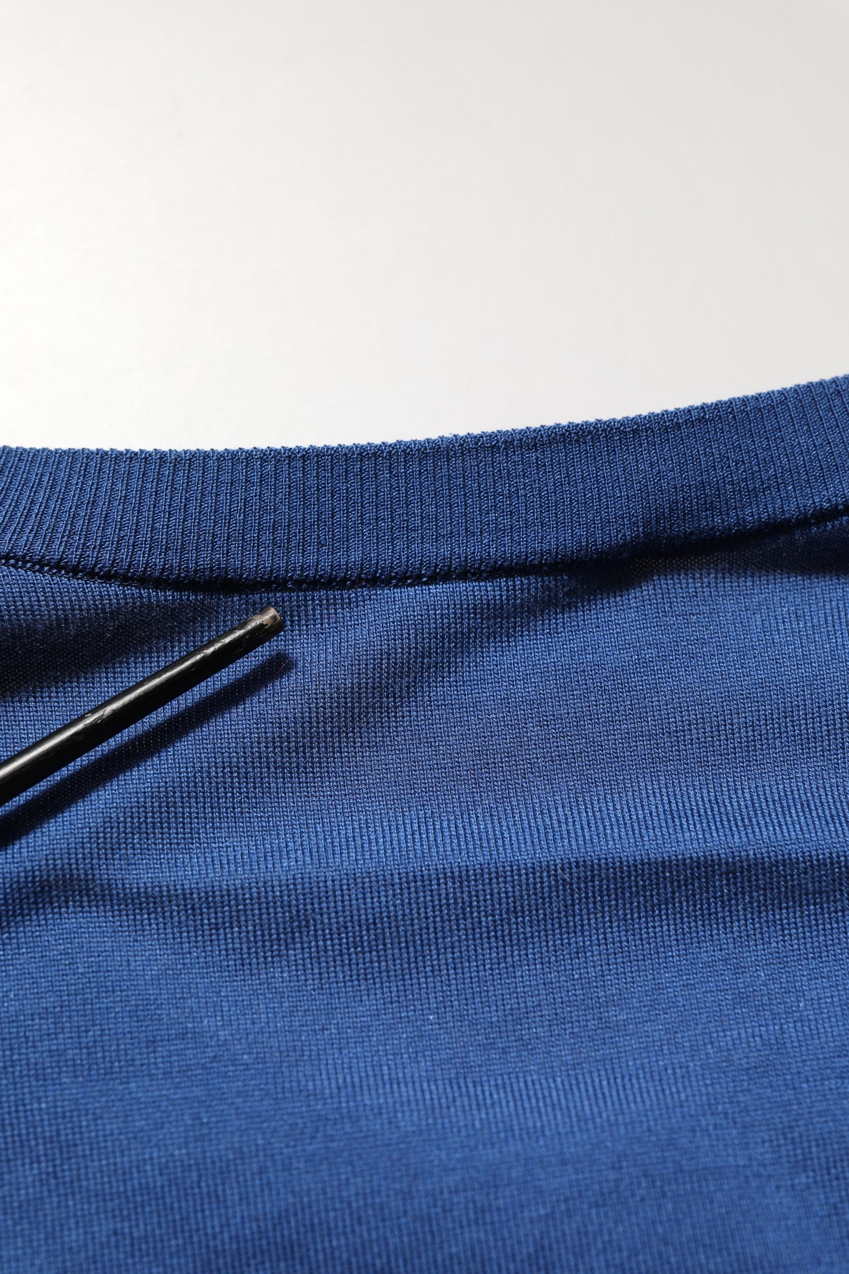 Pull doux Dolce & Gabbana en soie bleue avec logo DG sur le col ras du cou, style élégant et confortable.