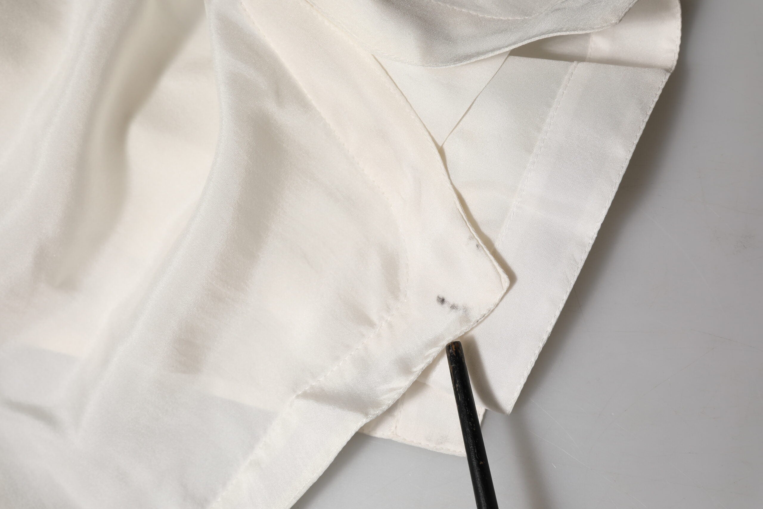 Chemise polo en soie blanche Dolce & Gabbana avec boutons, vue de face sur un fond neutre.