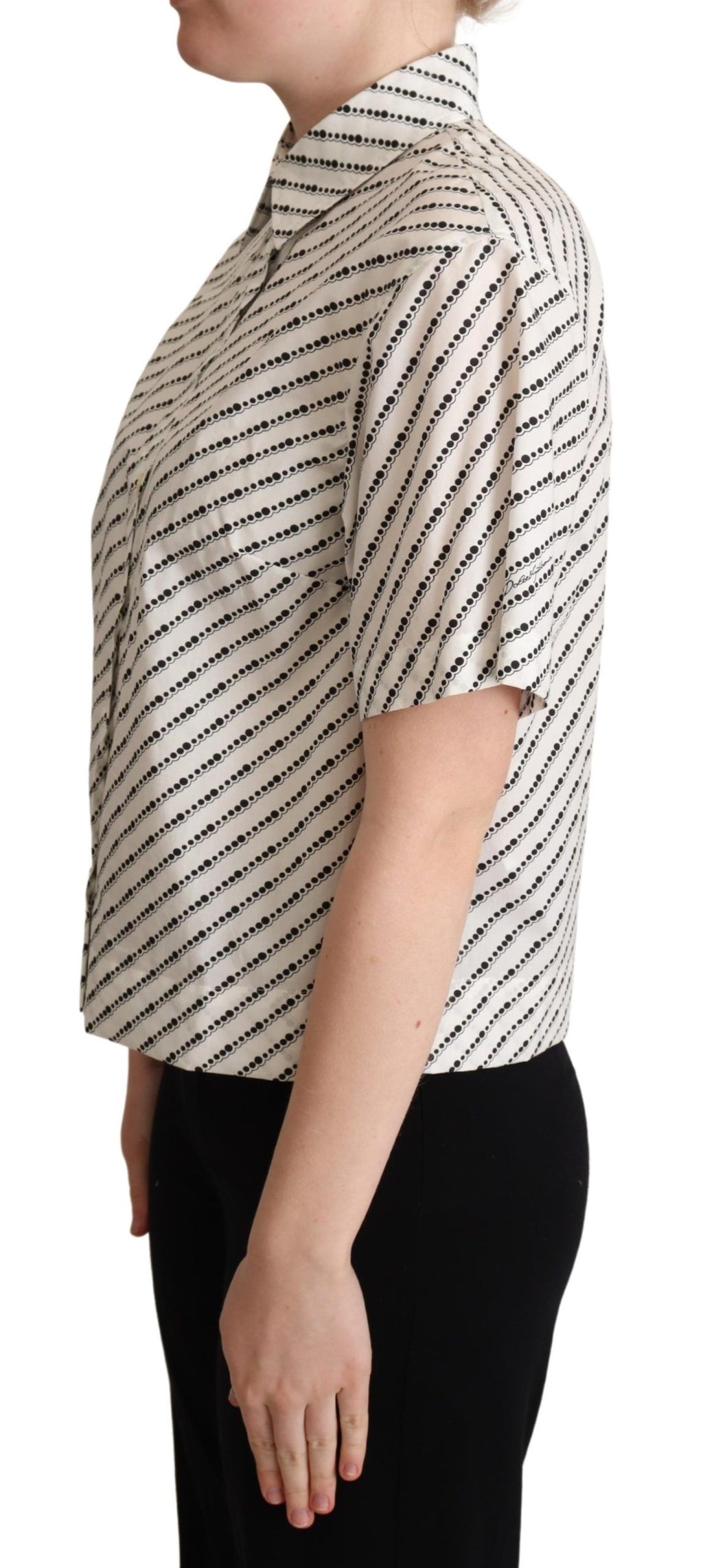 Chemise blanche à pois Dolce & Gabbana avec col, en tissu léger, visible avec détails de boutons et motifs à pois.