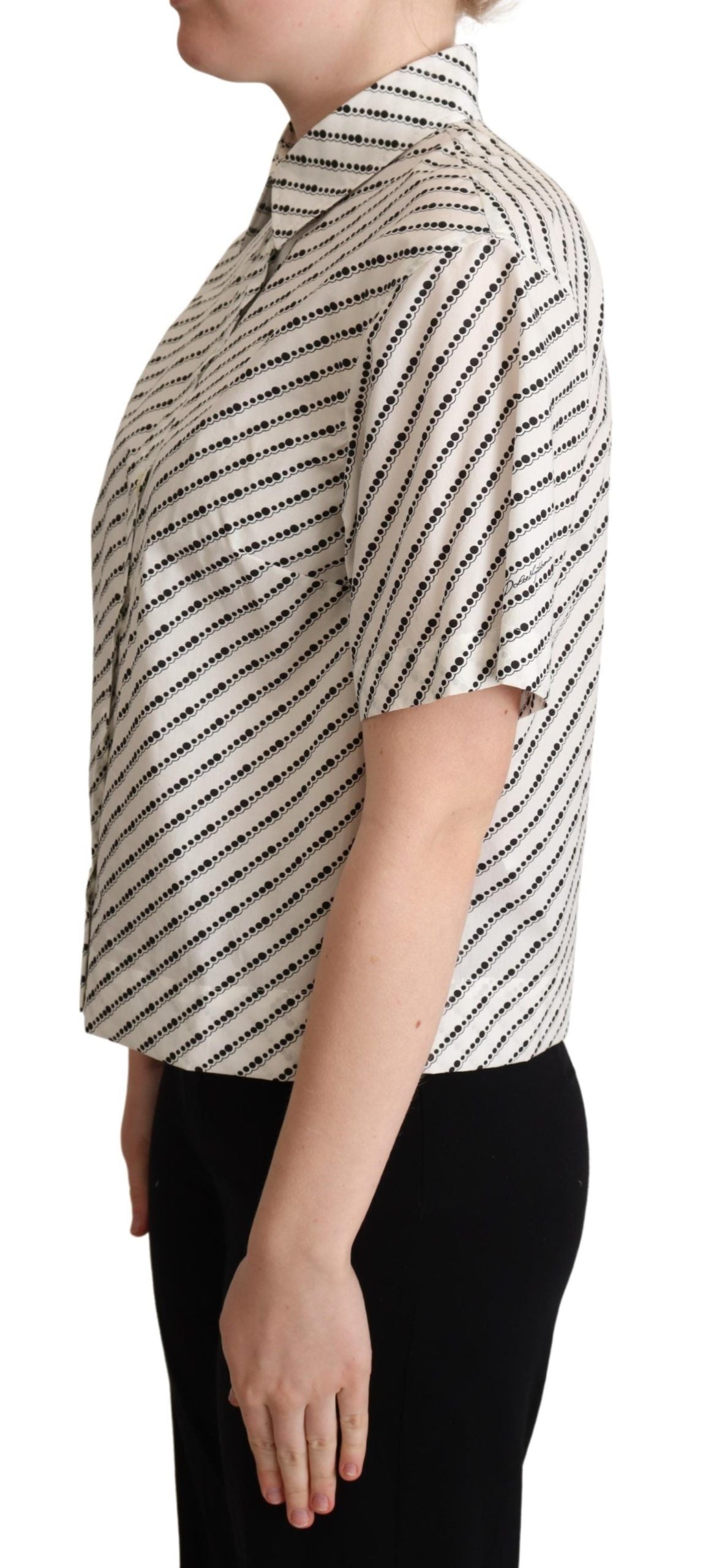 Chemise blanche à pois Dolce & Gabbana avec col, en tissu léger, visible avec détails de boutons et motifs à pois.